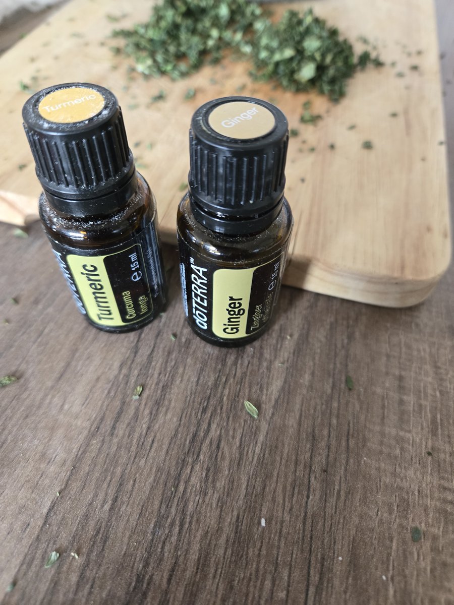 Ätherische Öle Ingwer und Kurkuma neben frischen Kräutern