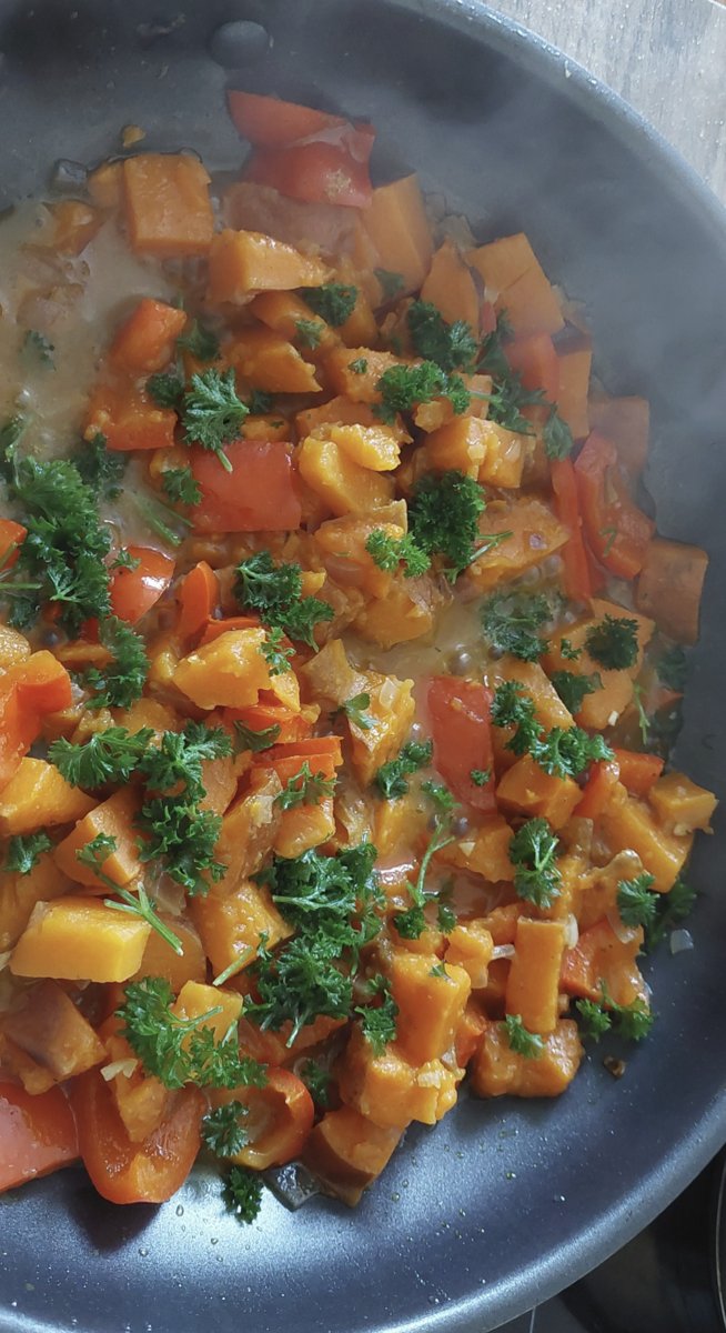 Süßkartoffel-Pfanne mit Paprika und frischer Petersilie in der Pfanne